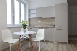 a kitchen with a table, chairs and a refrigerator at City Center Best Place Apartments in Bratislava