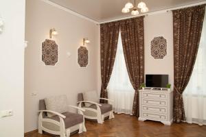 リヴィウにあるLuxury Lviv Apartmentのリビングルーム(椅子2脚、テレビ付)