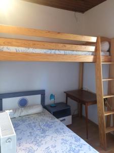 1 Schlafzimmer mit 2 Etagenbetten und einem Schreibtisch in der Unterkunft Appartement au cœur du parc national des Cévennes in L'Espérou