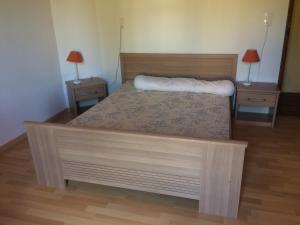 a bedroom with a bed with two nightstands and two lamps at Appartement au cœur du parc national des Cévennes in L'Espérou