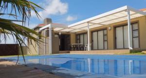 a house with a swimming pool in front of it at B.R.O.Homes and Villas in Port Elizabeth