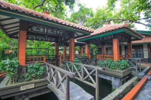 un petit bâtiment avec un pont devant lui dans l'établissement Sapta Nawa Resort 1 Gresik, à Gresik