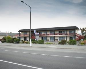 a building on the side of a street with a street light at Alpine Motel in Oamaru