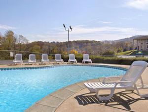 a swimming pool with lounge chairs next to at Express Inn Harrisburg South New Cumberland in New Cumberland