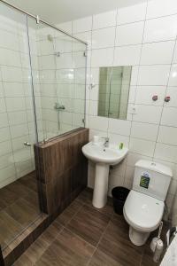 a bathroom with a toilet and a sink and a shower at City Fox Hotel in Barnaul