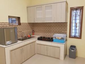 a kitchen with a sink and a counter top at De Hanami Homestay in Cirebon