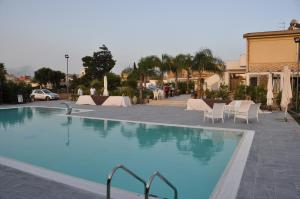 una grande piscina con sedie bianche e tavolo di I Giardini di Elencosta a Rilievo