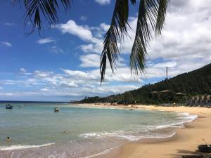 a beach with people in the water and a palm tree at Confetti House in Quy Nhon
