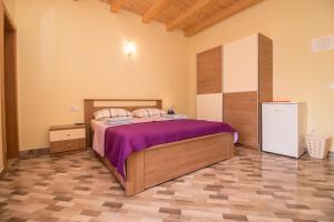a bedroom with a bed with purple sheets and a refrigerator at Nice place in Rovinj