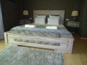 a bedroom with a wooden bed with two pillows at Hotel Nikala in Tskaltubo