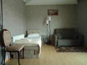 a bedroom with a bed and a chair and a couch at Hotel Nikala in Tskaltubo