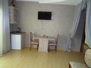 a room with a table and two chairs and a television at Hotel Nikala in Tskaltubo