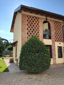 a large bush in front of a brick building at L'ago nel pagliaio in Turbigo