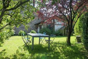 a table and chairs in the grass in a yard at Ancien relais de la diligence in Sart