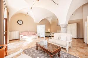 a living room with white furniture and a table at Agriturismo La Filanda in Manerba del Garda