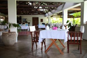 a dining room with a white table and chairs at Alexanders Hotel in Dar es Salaam