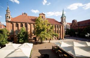 duży ceglany budynek z dwoma wieżami w obiekcie Apartamenty Stary Rynek 25 Toruń w Toruniu