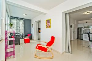 a living room with red chairs and a purple ladder at Apartments Dorijan in Beautiful House in Hvar +29 photos