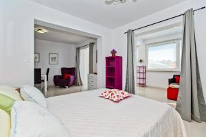 a white bedroom with a large bed with a pink cabinet at Apartments Dorijan in Beautiful House in Hvar