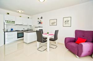 a kitchen and living room with a table and a purple chair at Apartments Dorijan in Beautiful House in Hvar