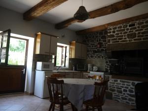 a kitchen with a table and a stone wall at Chambres d'Hotes Les Sageais in Baguer-Morvan