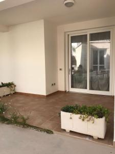 um pátio com 2 plantas e uma porta de vidro deslizante em Appartamento Ivana em Favignana