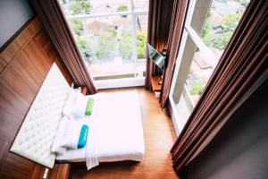Habitación con cama y ventana grande. en Grand Tebu Hotel en Bandung