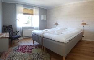 1 dormitorio con 1 cama blanca grande y ventana en Mittes Rum en Alingsås