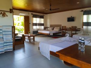 a hotel room with two beds and a tv at Eco Hotel Black & White - Anuradhapura in Mihintale