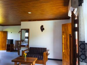 uma sala de estar com um sofá e uma mesa em Eco Hotel Black & White - Anuradhapura em Mihintale