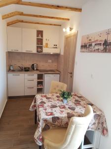 a kitchen with a table and chairs and a kitchen with white cabinets at Apartments Peranovic 2 in Kotor