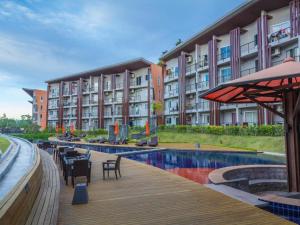 a hotel with a swimming pool with tables and chairs at Replay Condo Studio Room in Bangrak Beach