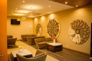 una sala de espera con sofás y espejos en la pared en The Streamliner Hotel Apartment en Toamasina