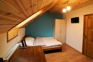 a bedroom with a bed and a wooden ceiling at Noclegi Azyl in Krajno-Zagórze