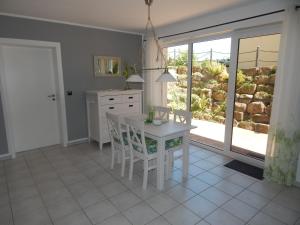a white kitchen with a white table and chairs at Ferienwohnung Zur Egge in Bad Driburg