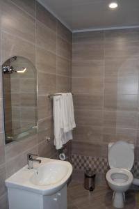 a bathroom with a toilet and a sink at Family Hotel Neliya in Velingrad