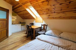 1 dormitorio con cama, mesa y cocina en Noclegi Azyl, en Krajno-Zagórze