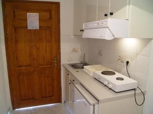 a kitchen with a counter with a sink and a door at Villa Maro in Skopelos Town