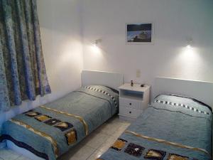 a bedroom with two beds and a dresser at Villa Maro in Skopelos Town