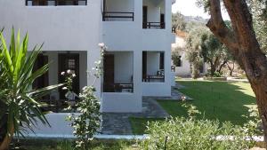 a white house with a green yard in front of it at Villa Maro in Skopelos Town