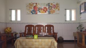 a room with a table and three chairs and a table and a table at Scarecrow Homestay in Jincheng