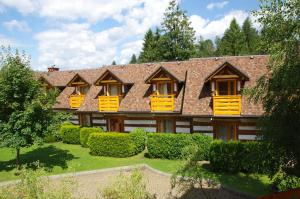 una grande casa con finestre gialle e cespugli di Kamratowo a Wisła