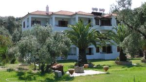 a large white house with trees in the yard at Villa Maro in Skopelos Town