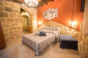 ein Schlafzimmer mit einem Bett und einer Steinmauer in der Unterkunft Il palazzetto del pescatore in Augusta