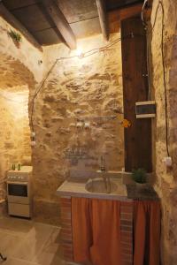eine Küche mit einem Waschbecken und einer Steinmauer in der Unterkunft Il palazzetto del pescatore in Augusta