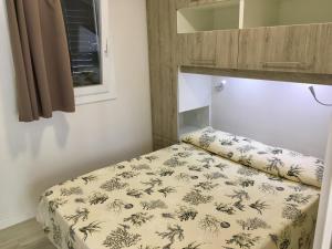 un letto in una piccola camera con lenzuola di Da Benedetto a Gaeta