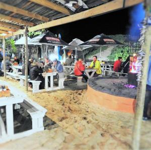 a group of people sitting at tables under umbrellas at Pili Pili Beach Cabanas in Sedgefield