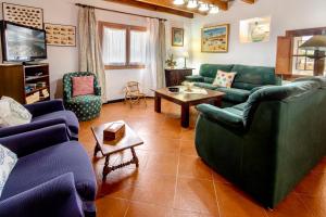 Una sala de estar con sofás azules y una mesa. en Villa Suari, en Pollensa