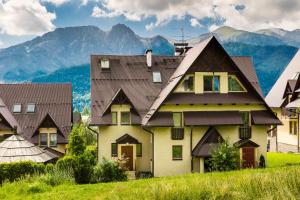 コシチェリスコにあるW Rent like home - Pod Blachówkąの山を背景にした丘の上の家