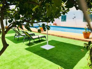 a lawn with chairs and a swimming pool at 5 Soles Hostal Rural in Carmona